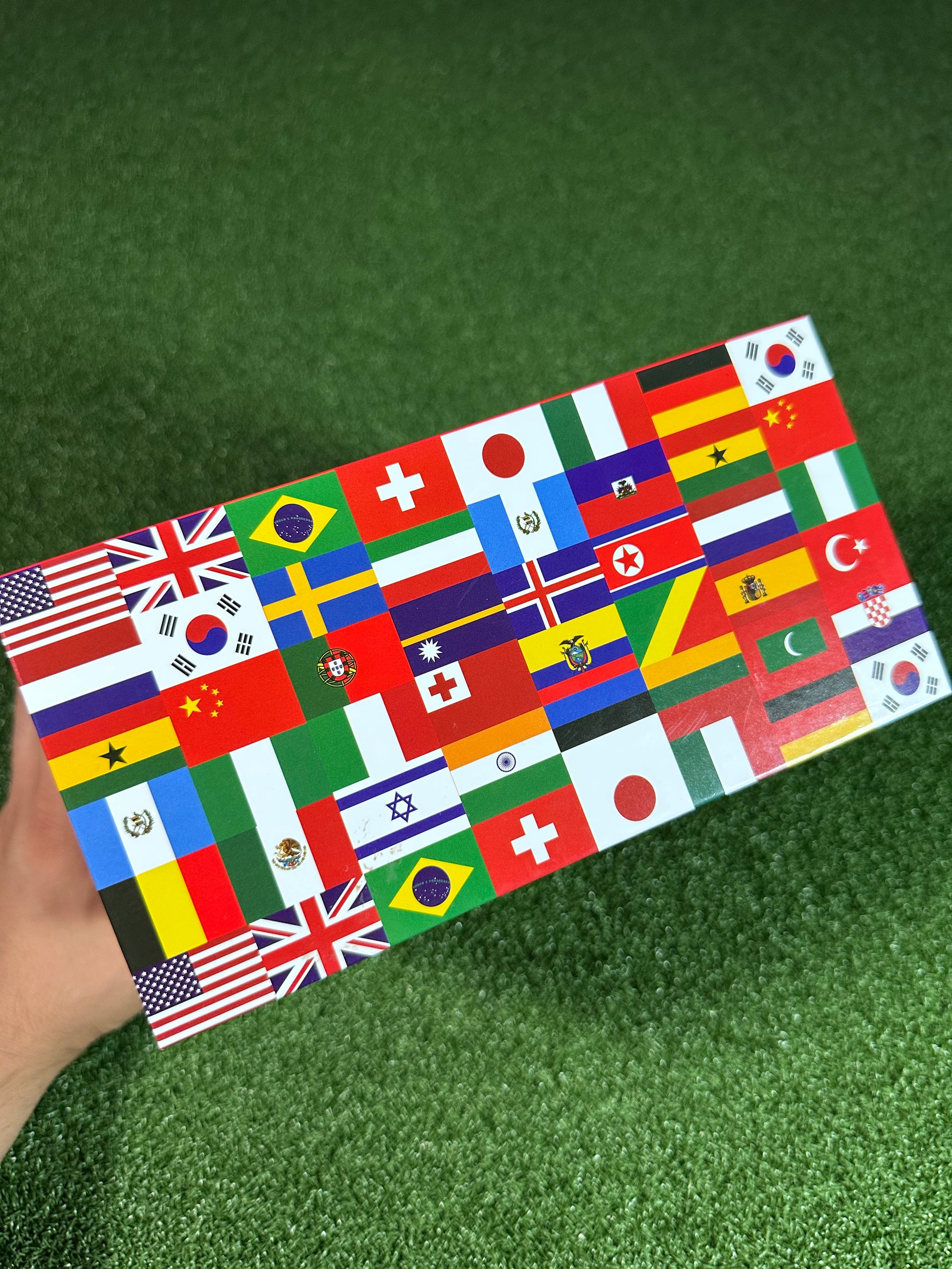 Card with various national flags on a green grass background